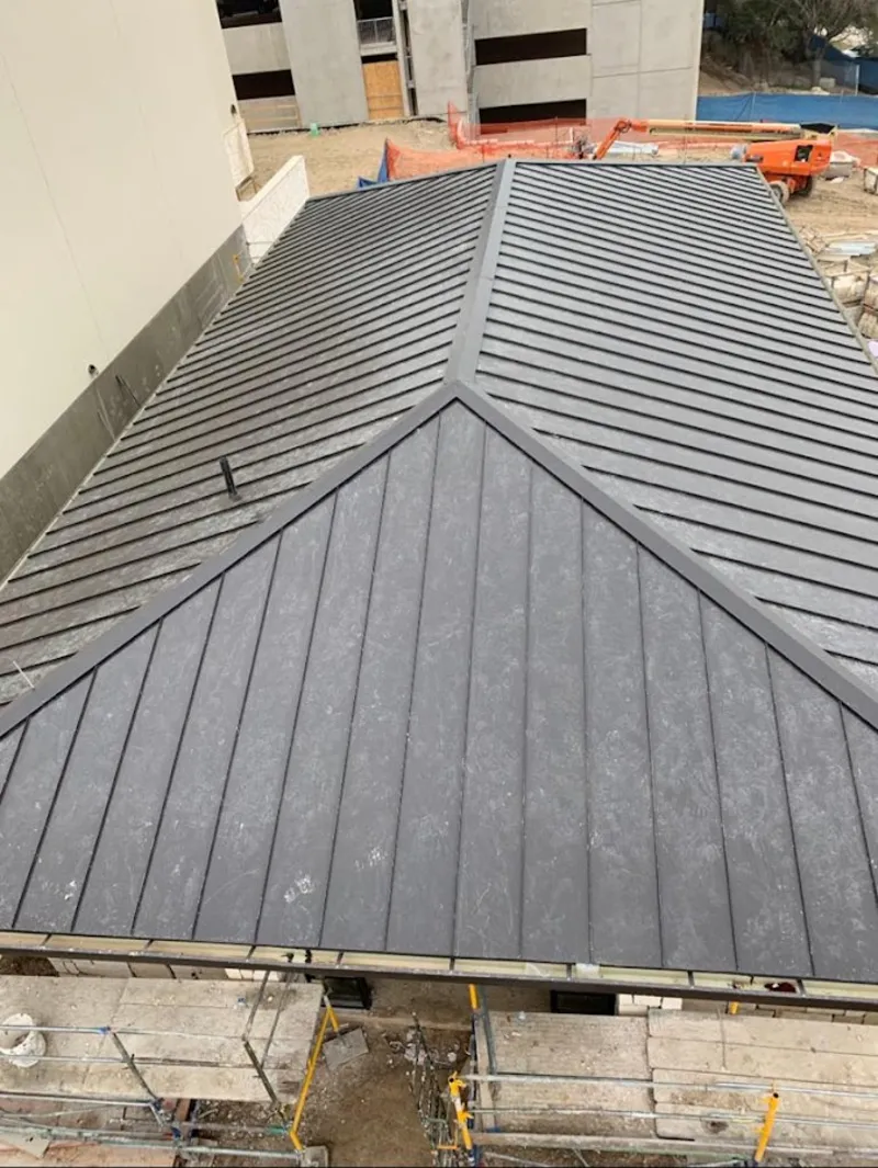 Commercial metal roof construction with crane equipment in West Deptford